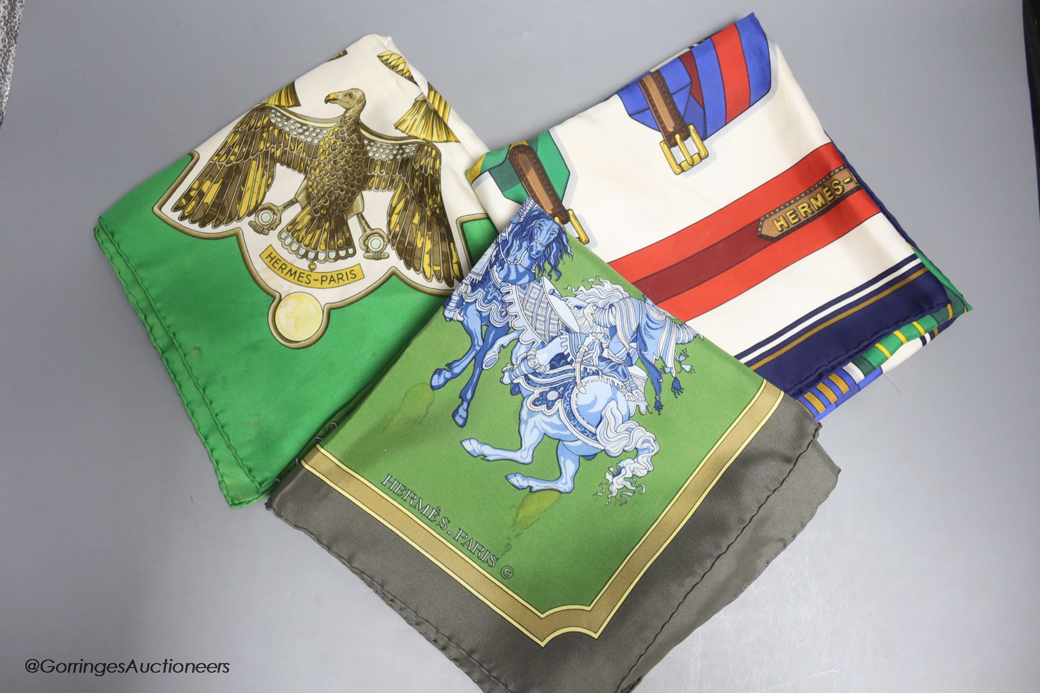 Three vintage Hermes silk scarves, 'Scarabee et Pectoraux' (gold, green, white), 'Carrousel' (green ground), and 'Sangles' (multi)